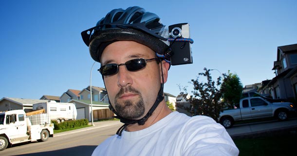Man with camera attached to cycle helmet